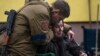 Un soldado consuela a Larysa Kolesnyk, de 82 años, luego de que fuera evacuada de Irpín, en las afueras de Kiev, Ucrania.