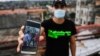 Rolando Remedios muestra una foto en su celular de su arresto durante las protestas del 11 de julio. (YAMIL LAGE / AFP)